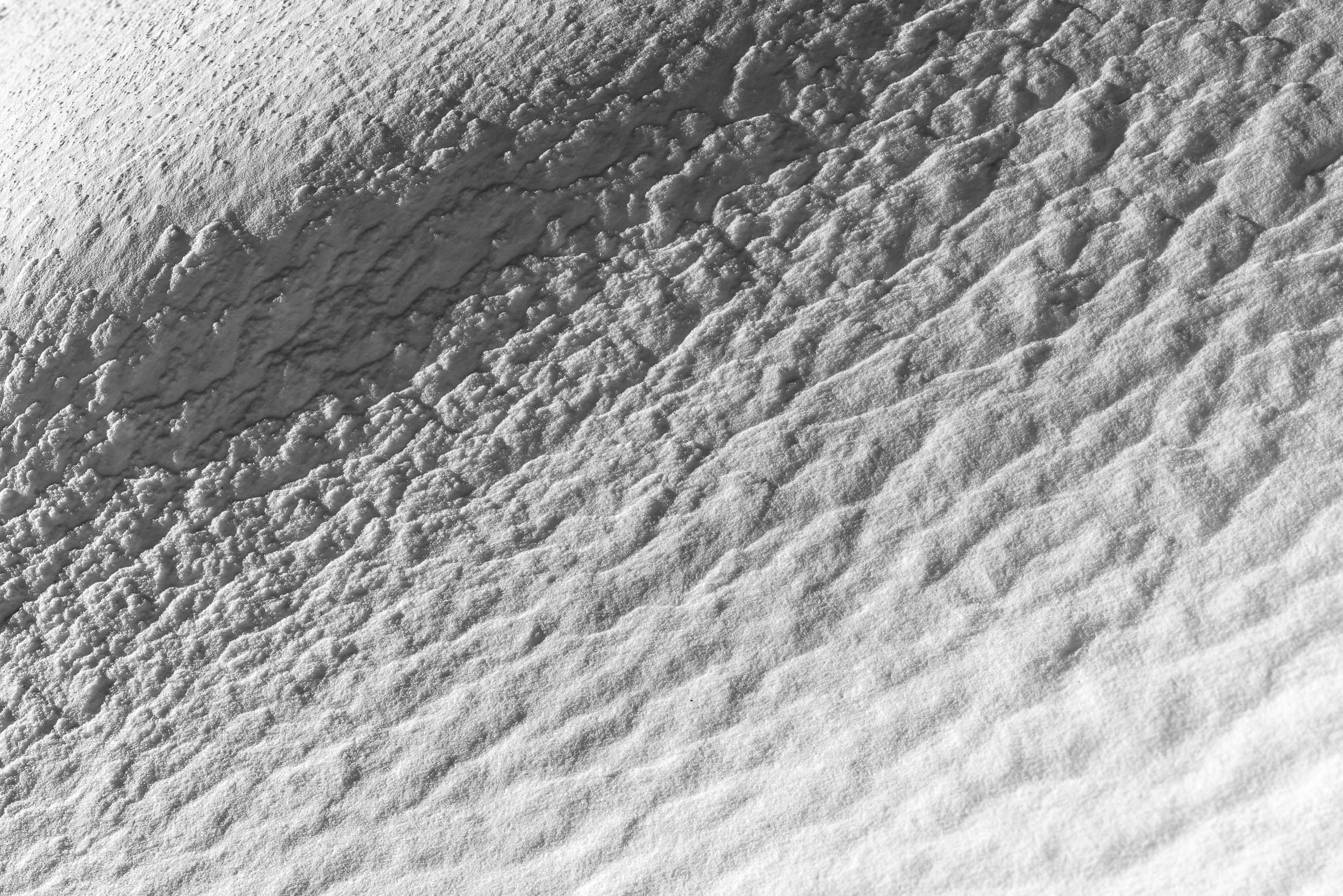 Fotografia in bianco e nero evidenzia la texture sulla neve creata dal vento