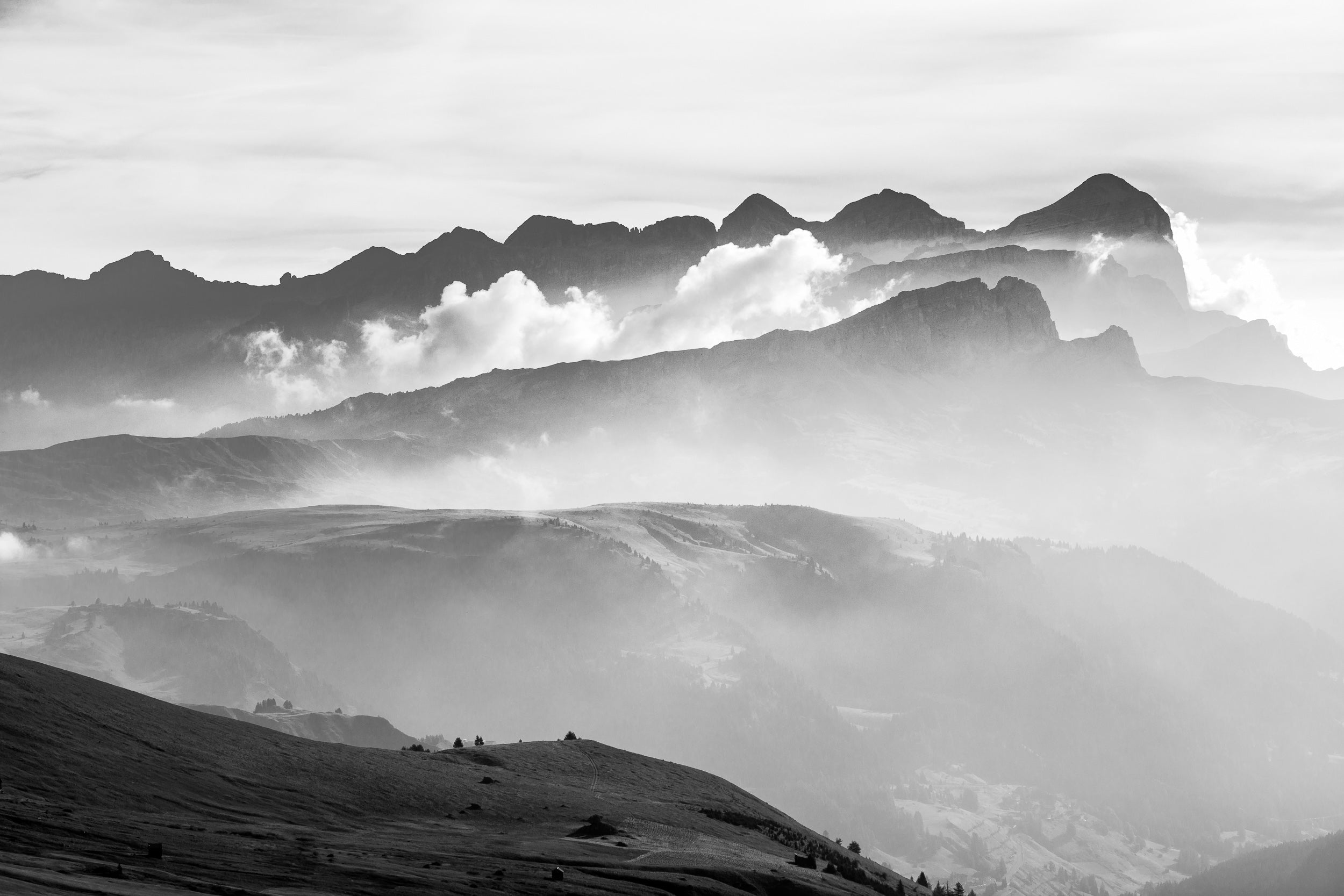 Fotografia in bianco e nero con vista dal Passo Pordoni verso il Gruppo delle Tofane con foschia mattutina