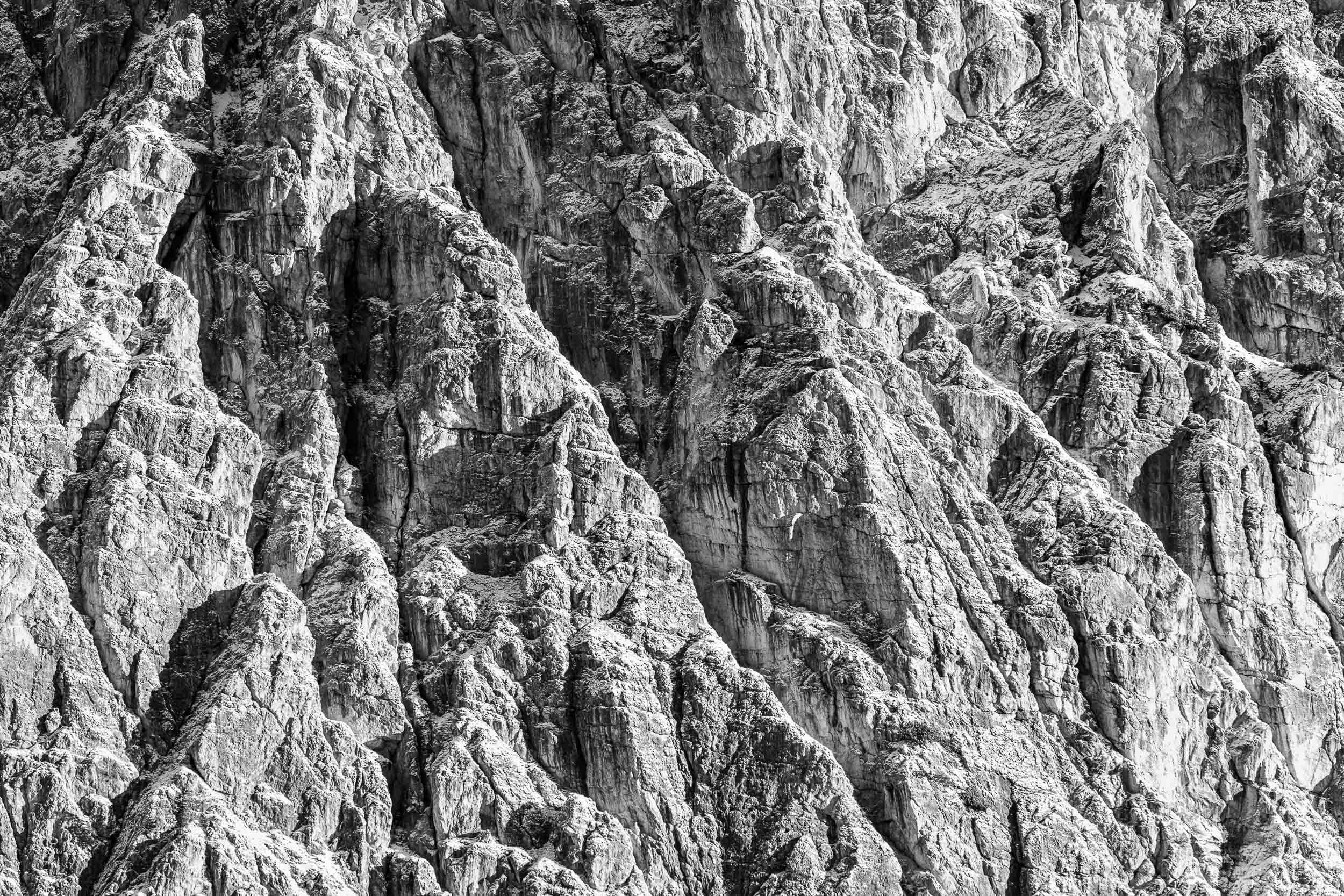 Fotografia in bianco e nero di una parete di dolomia leggermente innevata
