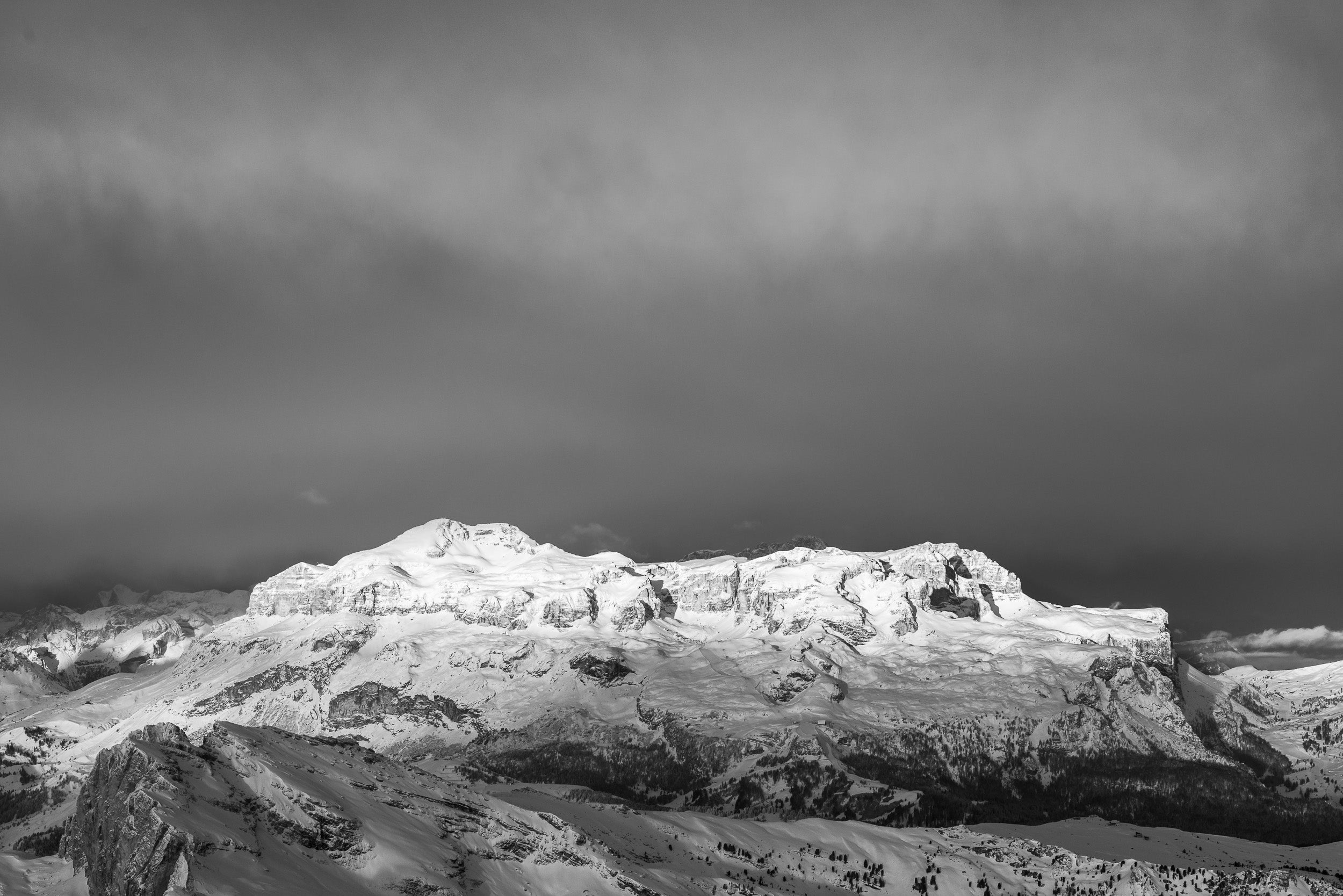 Fotografia invernale in bianco e nero del Gruppo del Sella alle prime luci del mattino dopo una nevicata