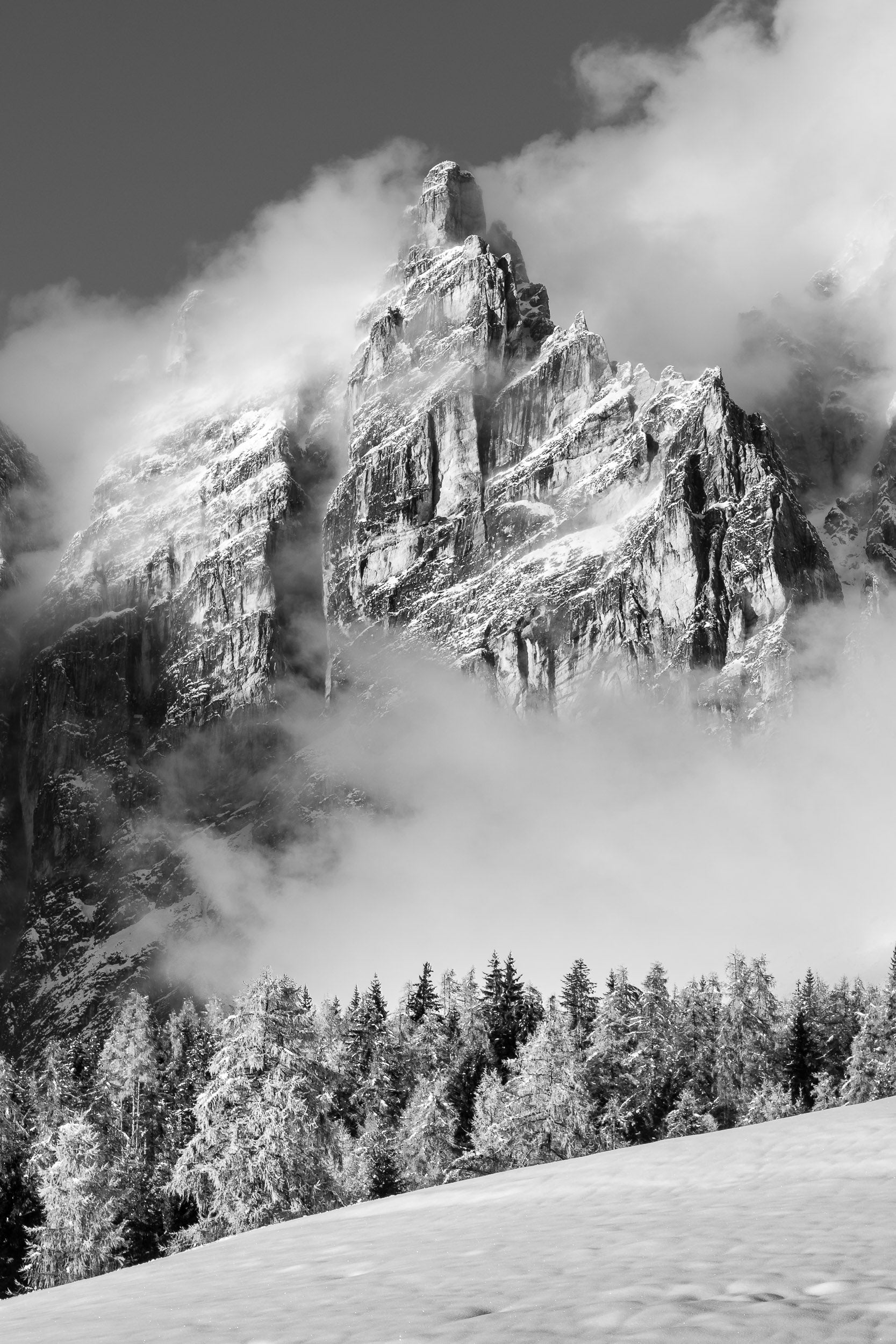 Fotografia in bianco e nero, nebbie avvolgono il Campanile Dimai dopo una nevicata