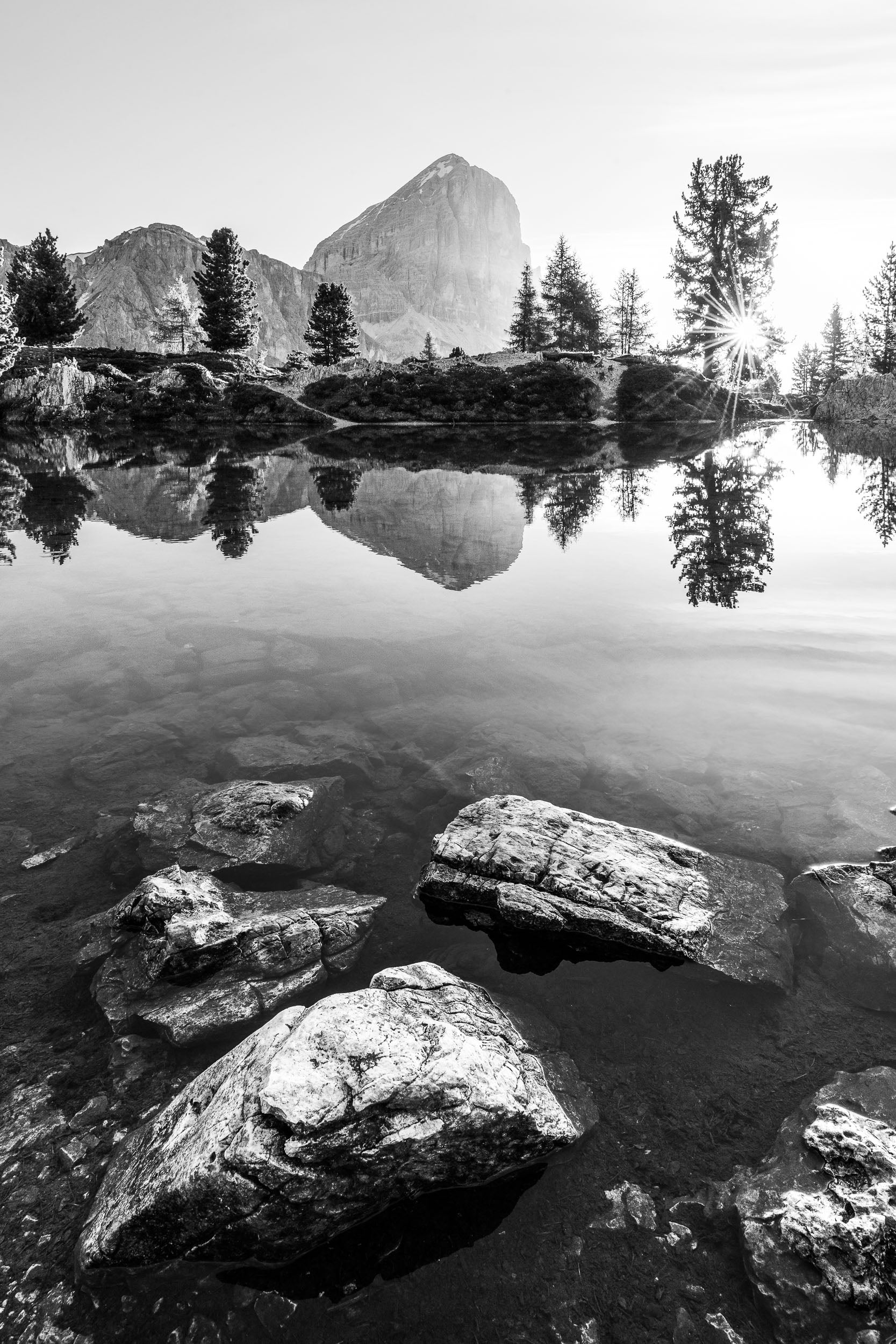 Fotografia verticale in bianco e nero del lago di Limides verso la Tofana di Rozes